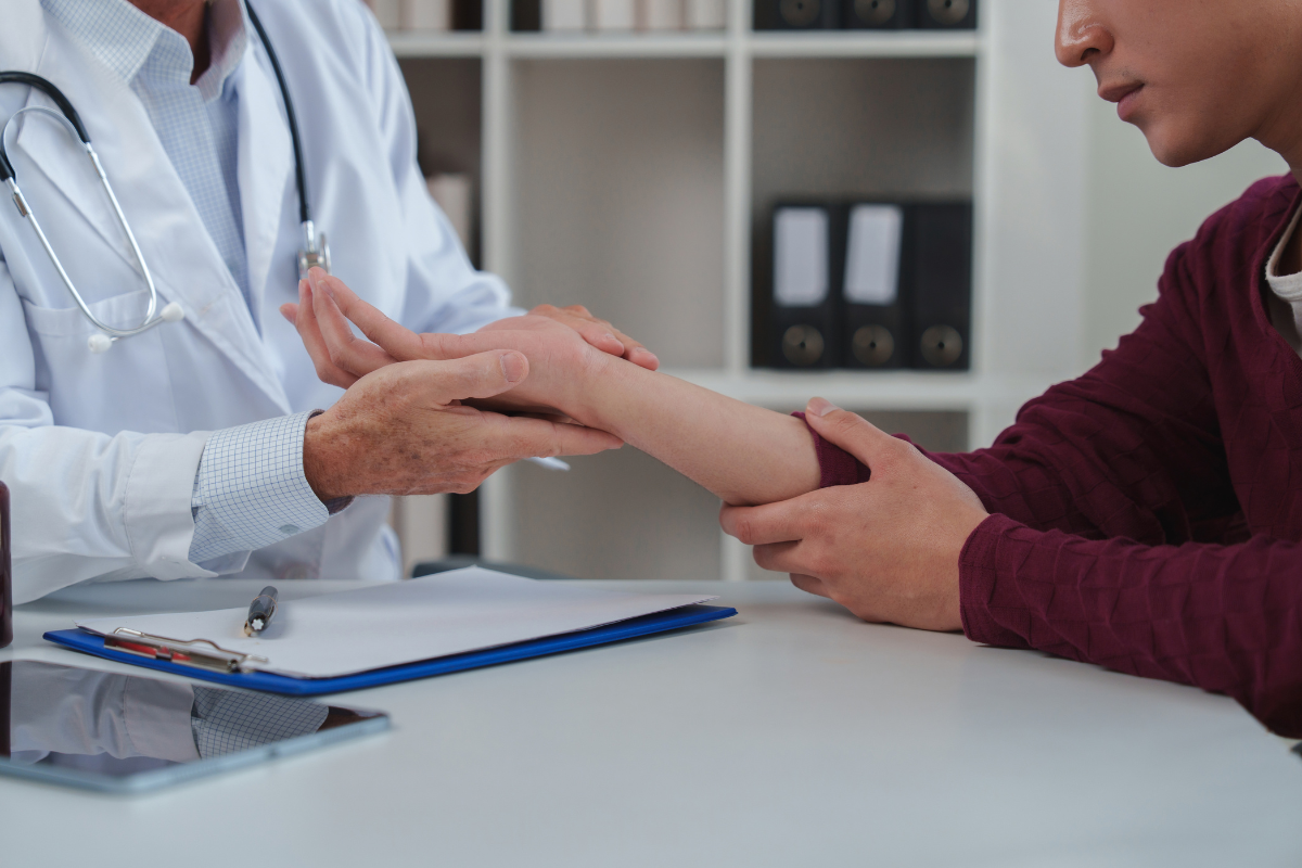 A doctor examining the hand of a patient with carpal tunnel syndrome in the Cayman Islands.