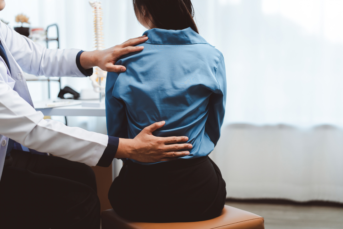 A doctor examining a patient with back pain before administering an epidural steroid injection in the Cayman Islands.